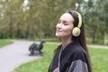 Young happy woman listening music from smartphone with headphones in a quiet Park Royalty Free Stock Photo