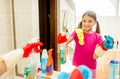 Happy smiling girl polishing mirror at bathroom with cloth