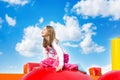 Happy Smiling Girl Sitting on Inflate Castle Royalty Free Stock Photo