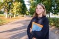 Happy smiling Girl teenager 12-15 years old, autumn day, street portrait, summer park. In hand notebooks folders Royalty Free Stock Photo