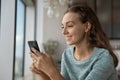 Happy smiling girl using mobile phone, reading text