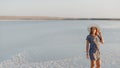 Happy smiling girl in white hat enjoying sun, expanse of Bascunchak salt lake