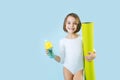 Happy smiling girl in a white leotard with rolled mat and water bottle over blue Royalty Free Stock Photo