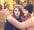 Happy Smiling Girls with Cell Phone Taking Selfie in Autumn Park Royalty Free Stock Photo