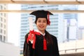 Happy smiling graduated student, young beautiful Asian woman warming square academic hat cap and giving certificate to camera, Royalty Free Stock Photo