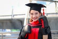 Happy smiling graduated woman student warming square academic hat cap with red boxing gloves or mitt punch, the metaphors about