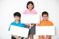 Happy smiling group of kids showing blank placard board. Royalty Free Stock Photo