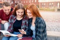 Happy smiling group of students studying outdoors near university