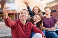 Happy smiling group of students taking picture on the phone outdoors near university Royalty Free Stock Photo