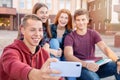 Happy smiling group of students taking picture on the phone outdoors near university Royalty Free Stock Photo