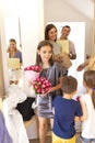 Happy smiling guests with presents standing in doorway. Focus on young female Royalty Free Stock Photo