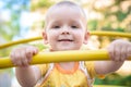 Happy smiling and handsome boy kid having fun playing at playground in a park on bright sunny day Royalty Free Stock Photo