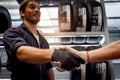 Happy smiling handsome worker man having firm handshake during working in garage automobile service center, car service technician Royalty Free Stock Photo