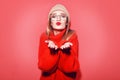 Happy Smiling Hipster Girl kiss in knitted red sweater and hat having fun . Cute girl in glusses with piercing in the nose. Royalty Free Stock Photo