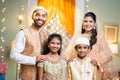 Happy smiling indian muslim parents with kids looking at camera during ramdan festival celebration - concept of