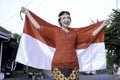 Happy smiling Indonesian woman wearing red kebaya holding Indonesia's flag to celebrate Indonesia Independence Day. Royalty Free Stock Photo