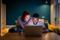 Happy smiling interracial couple man and woman look at laptop screen choosing movie in evening Royalty Free Stock Photo