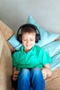 Happy smiling kid boy in headphones listen to music or audiobook Royalty Free Stock Photo