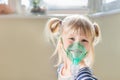 Happy smiling kid using nebuliser mask. Inhalation therapy curing chest cold and coughing. Healthcare and disease prevention conce