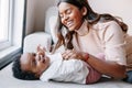 Happy smiling laughing Indian mother playing with black baby girl daughter. Family mixed race people mom and a kid together