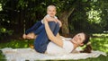 Happy smiling and laughing mother with baby son playing in garden while lying on grass. Parenting, family, children Royalty Free Stock Photo