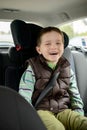 Happy smiling little boy in car safety seat. Royalty Free Stock Photo