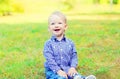 Happy smiling little boy child sitting on grass Royalty Free Stock Photo