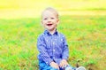 Happy smiling little boy child is sitting on the grass Royalty Free Stock Photo