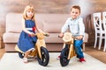 Happy little children riding a runbikes at home Royalty Free Stock Photo