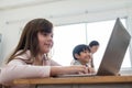 Happy Smiling little Cute girl using laptop while studying in classroom at international school Royalty Free Stock Photo