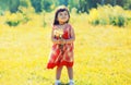 Happy smiling little girl child outdoors with bouquet of wildflowers walking in sunny summer park Royalty Free Stock Photo