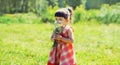 Happy smiling little girl child outdoors with bouquet of wildflowers walking in sunny summer park Royalty Free Stock Photo