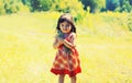 Happy smiling little girl child outdoors with bouquet of wildflowers walking in sunny summer park Royalty Free Stock Photo