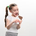 A happy and smiling little girl has a chocolate, portrait of a child with chocolate on a white background. Royalty Free Stock Photo