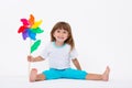 Happy smiling little girl holding a colorful toy pinwheel windmill isolated on white background Royalty Free Stock Photo