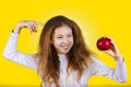 Happy, smiling little girl holding an red apple, pointing with f Royalty Free Stock Photo