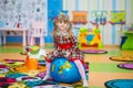 Happy smiling little girl jumping on a big rubber ball Royalty Free Stock Photo