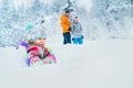 Happy smiling little girl sitting in deep snow when she walking with family in winter snowy forest Royalty Free Stock Photo