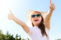 Happy smiling little girl in sunglasses, white t-shirt and summer hat against blue sky background Royalty Free Stock Photo