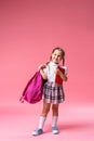 Happy smiling little girl in uniform with backpack goes to school for first time Royalty Free Stock Photo