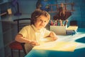 Happy smiling little kid boy at home making homework at the morning before the school starts. Royalty Free Stock Photo