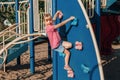 Happy smiling little preschool girl climbing rock wall at playground outside on summer day. Happy childhood lifestyle concept. Royalty Free Stock Photo