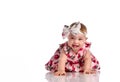 Happy little baby girl in dress crawling on floor