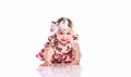 Happy little baby girl in dress crawling on floor