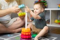 Happy smiling little toddler boy 2,5 years playing colorful pyramid with dad. Spending time with children. Royalty Free Stock Photo