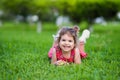 Happy Smiling Little Toddler Girl Laying On Grass In Park With Red Dress Royalty Free Stock Photo