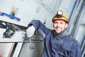 Smiling machinist with spanner adjusting lift in elevator shaft Royalty Free Stock Photo