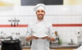 happy smiling male chef holding empty plate Royalty Free Stock Photo