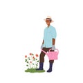 Happy smiling man gardener cartoon character watering flower bed from can isolated on white