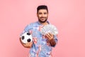 Happy smiling man holding showing soccer ball and fun of hundred dollar bills, winning lot of money Royalty Free Stock Photo